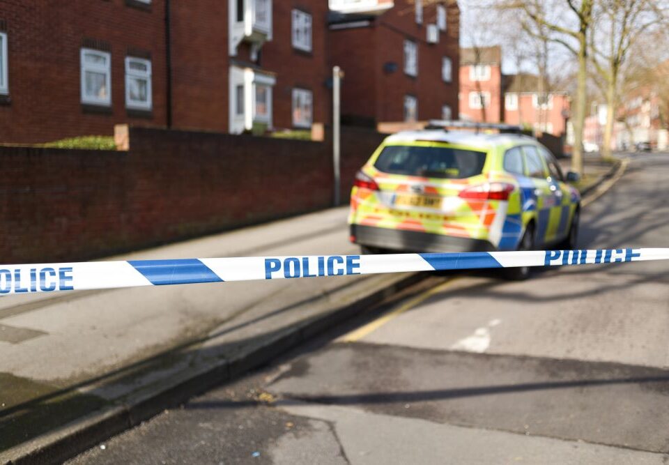 Image of police car and police cordon on UK street.